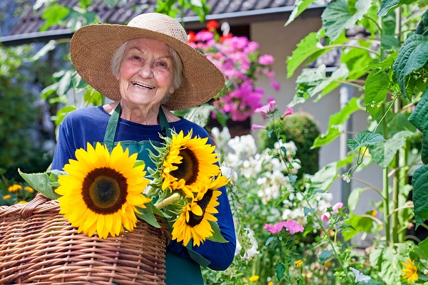 Older woman in a sunhat with a basket of flowers